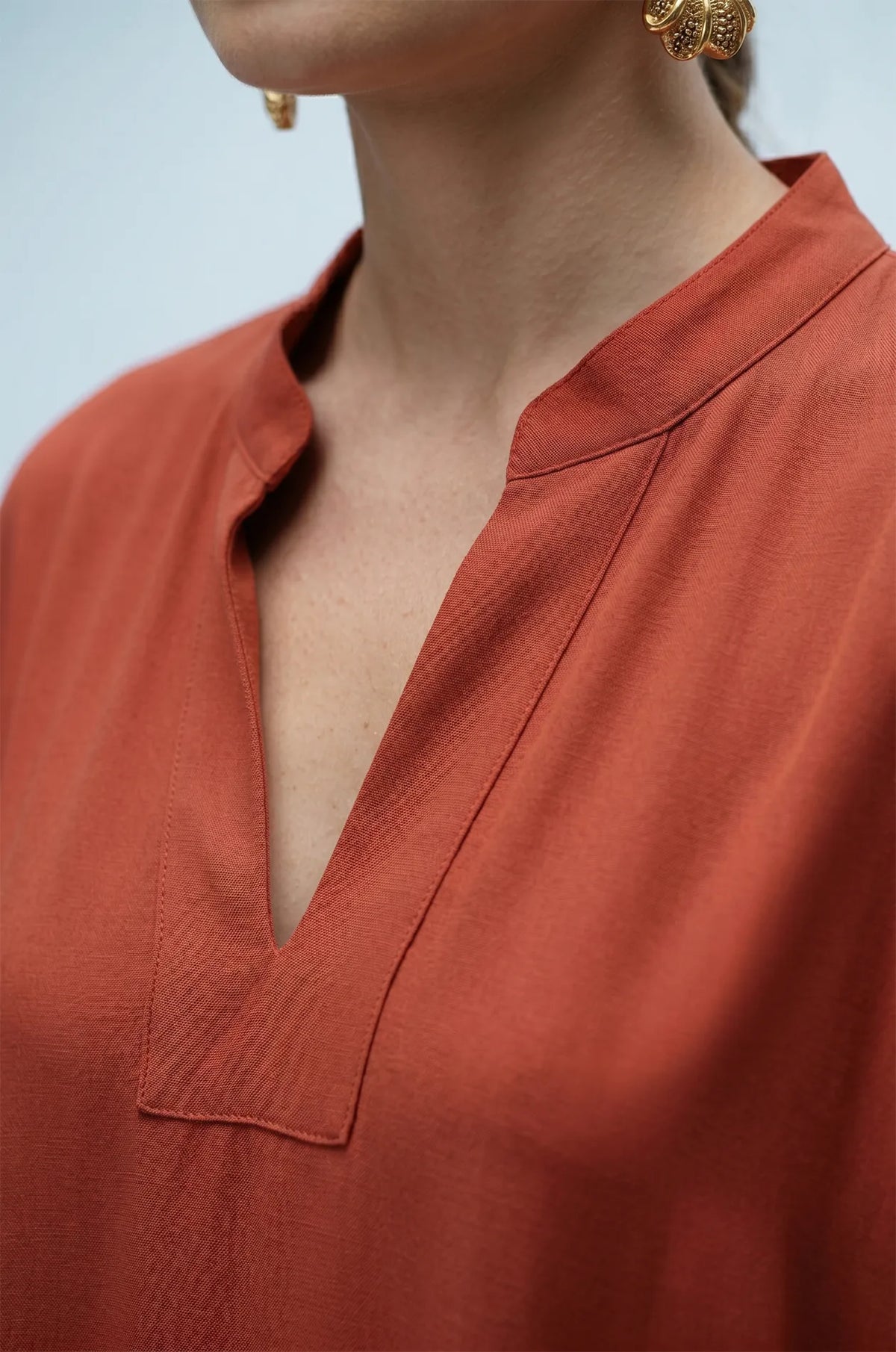 Close-up of terracotta orange plain kaftan split V-neckline detail