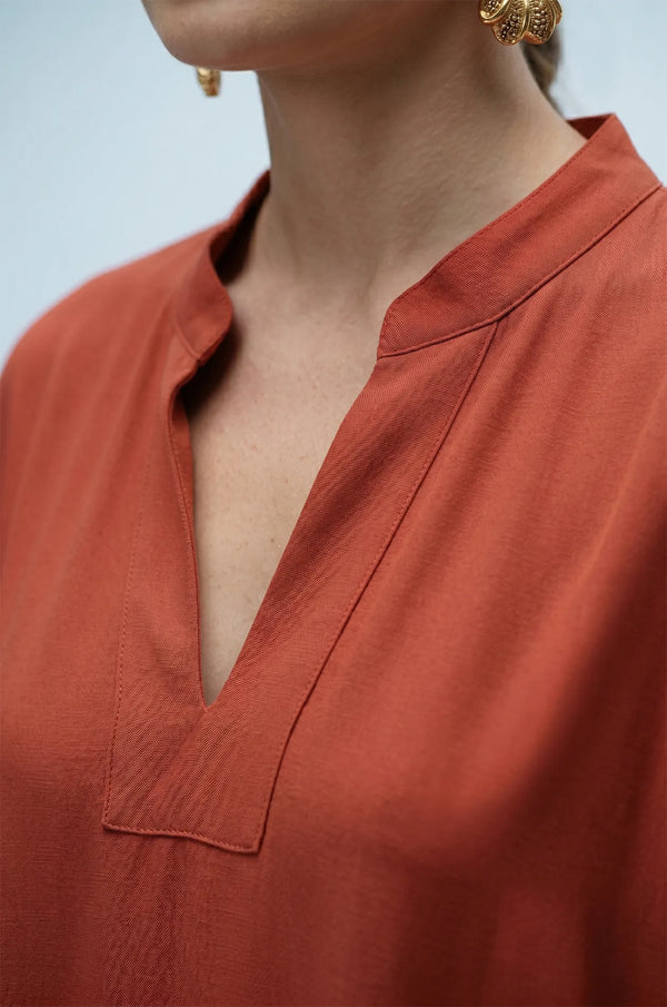 Close-up of terracotta orange plain kaftan split V-neckline detail