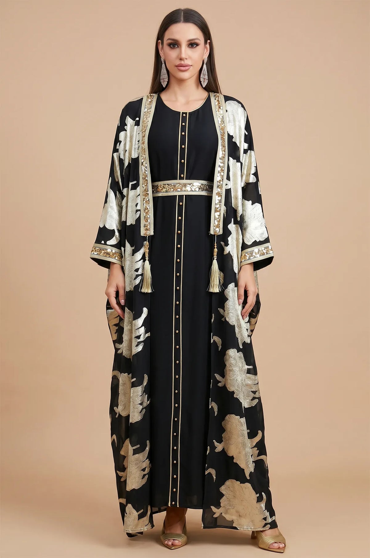 A professional studio shot of the Black Puppis kaftan luxe by Naylara with metallic gold botanical prints and floor-length drape.