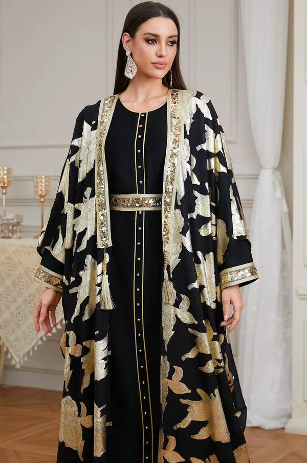 A detailed close-up of the Black Puppis kaftan luxe focusing on the gold buttons, sequined lapels, and luxury tassel accents.