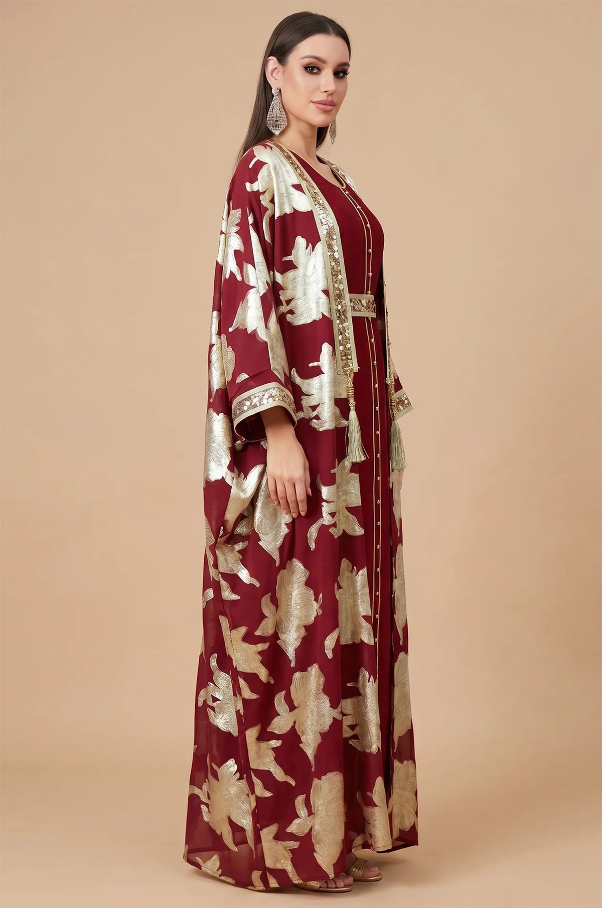 Side profile of the red and gold Puppis kaftan luxe highlighting the flowing butterfly sleeves and sophisticated silhouette.