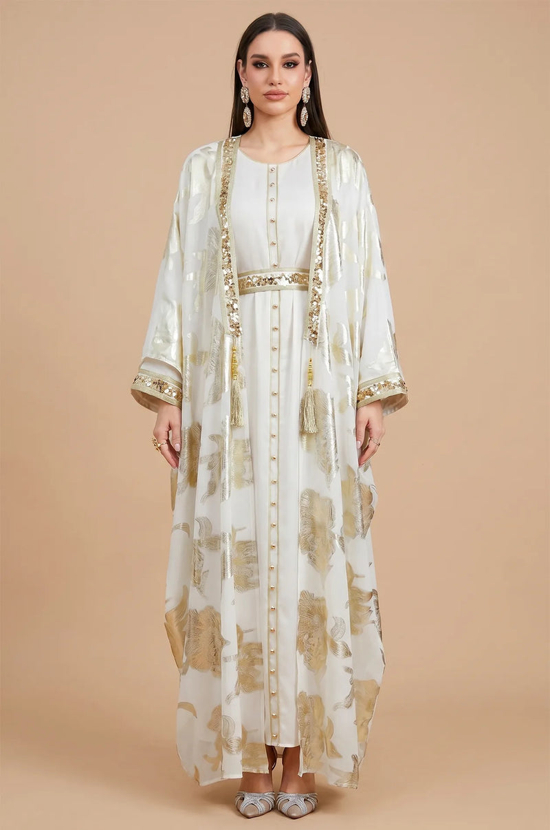 Frontal view of the Puppis white kaftan luxe with metallic gold botanical embroidery and a matching sequined belt.