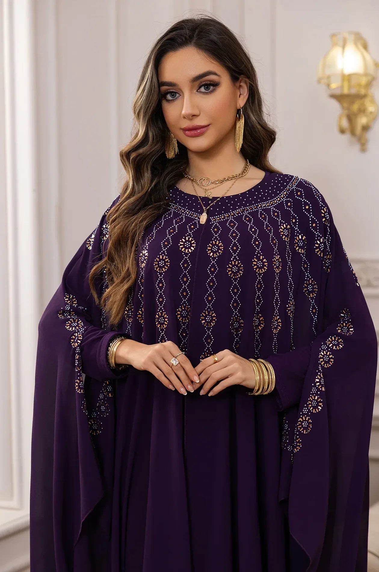 Portrait view of the Purple Cassia Kaftan highlighting the intricate rhinestone neckline and gold jewelry.