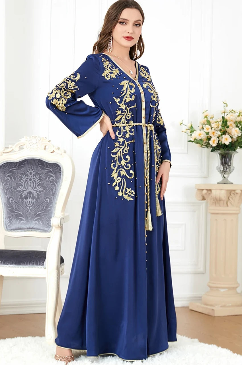 Rayah blue and gold kaftan worn standing in elegant pose