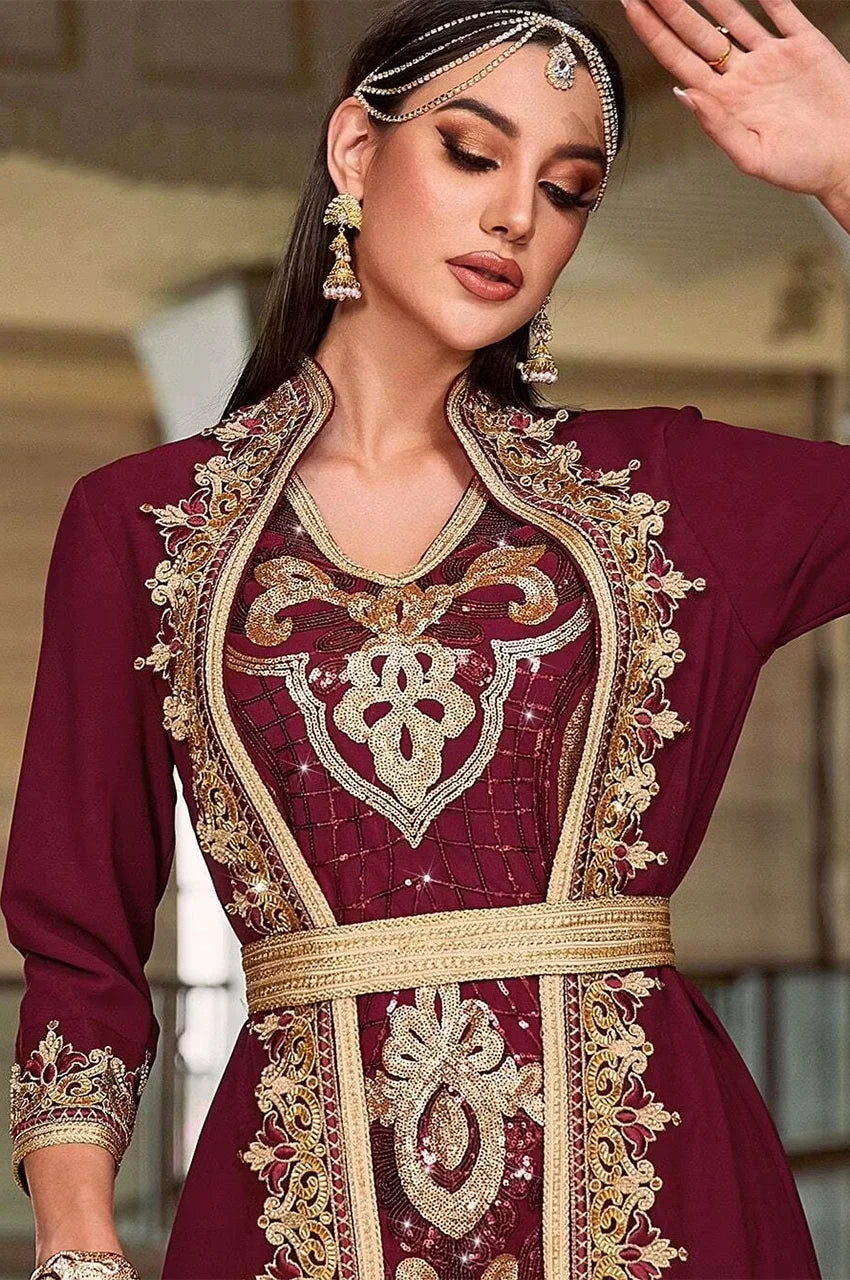 Close-up of gold Sfifa braided borders and floral embroidery on the red chiffon kaftan dress bodice.