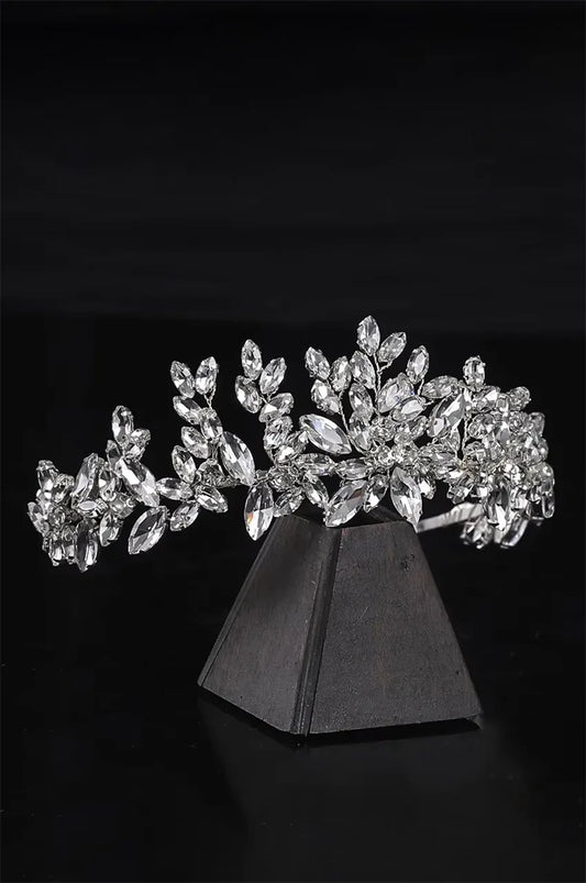 Side angle of sparkling rhinestone crown showing intricate leaf motif and silver setting.