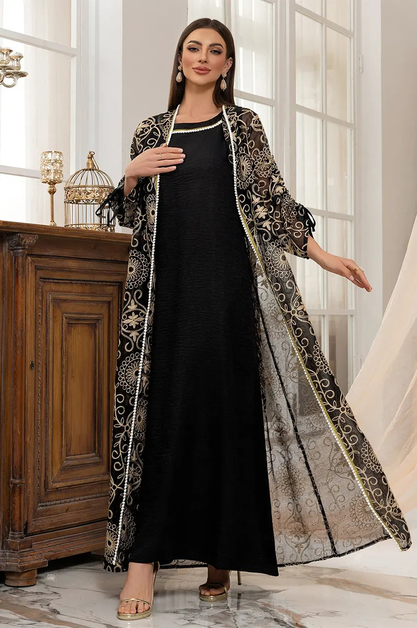 Dynamic shot highlighting the regal flow and movement of the embroidered tulle skirt on the RIYAA black chiffon kaftan.
