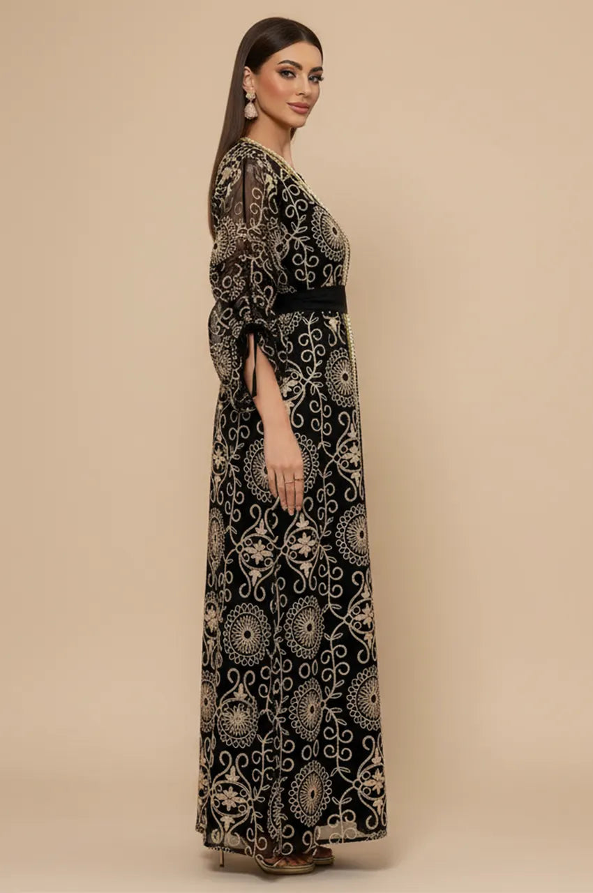 Side profile of model in Riyaa black chiffon kaftan highlighting sheer sleeves.