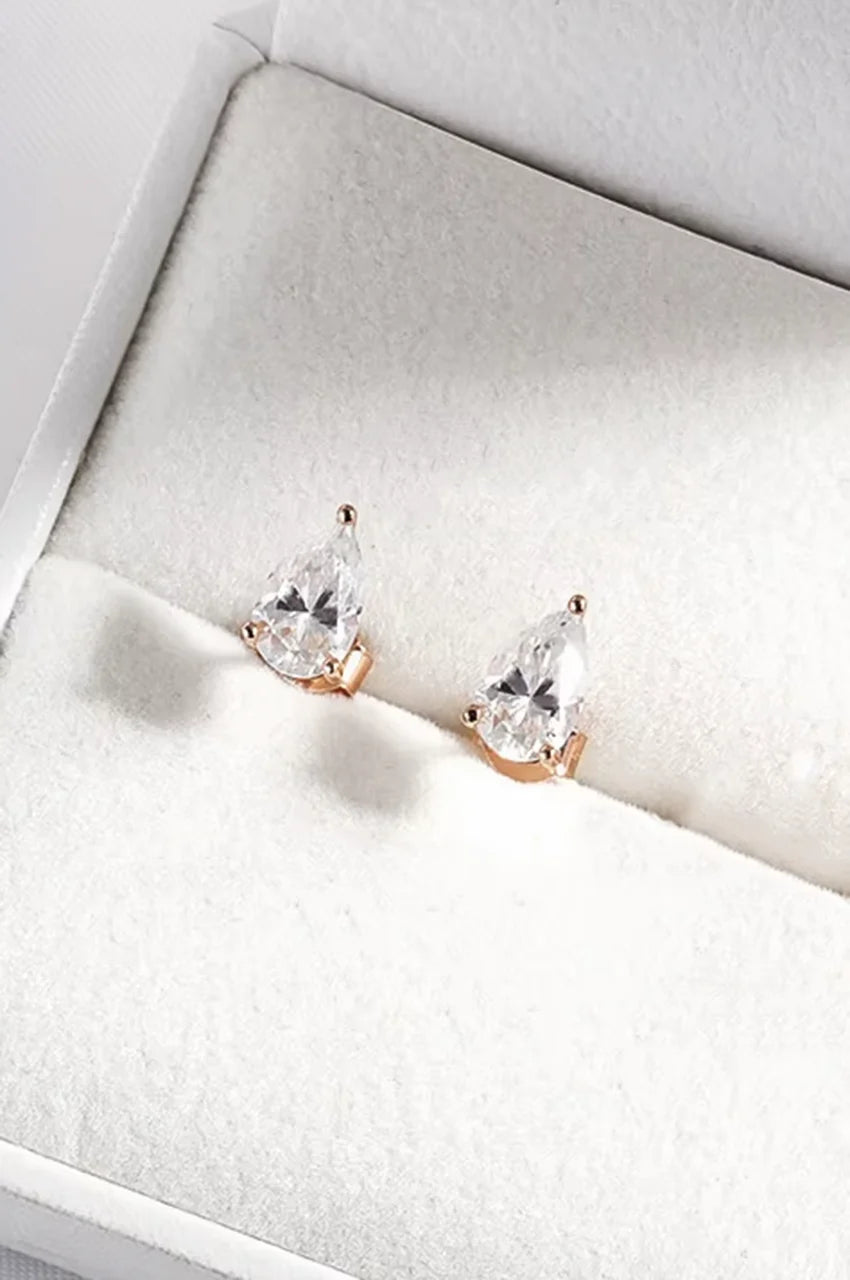 Rose gold teardrop crystal stud earrings sitting in a white jewelry box.