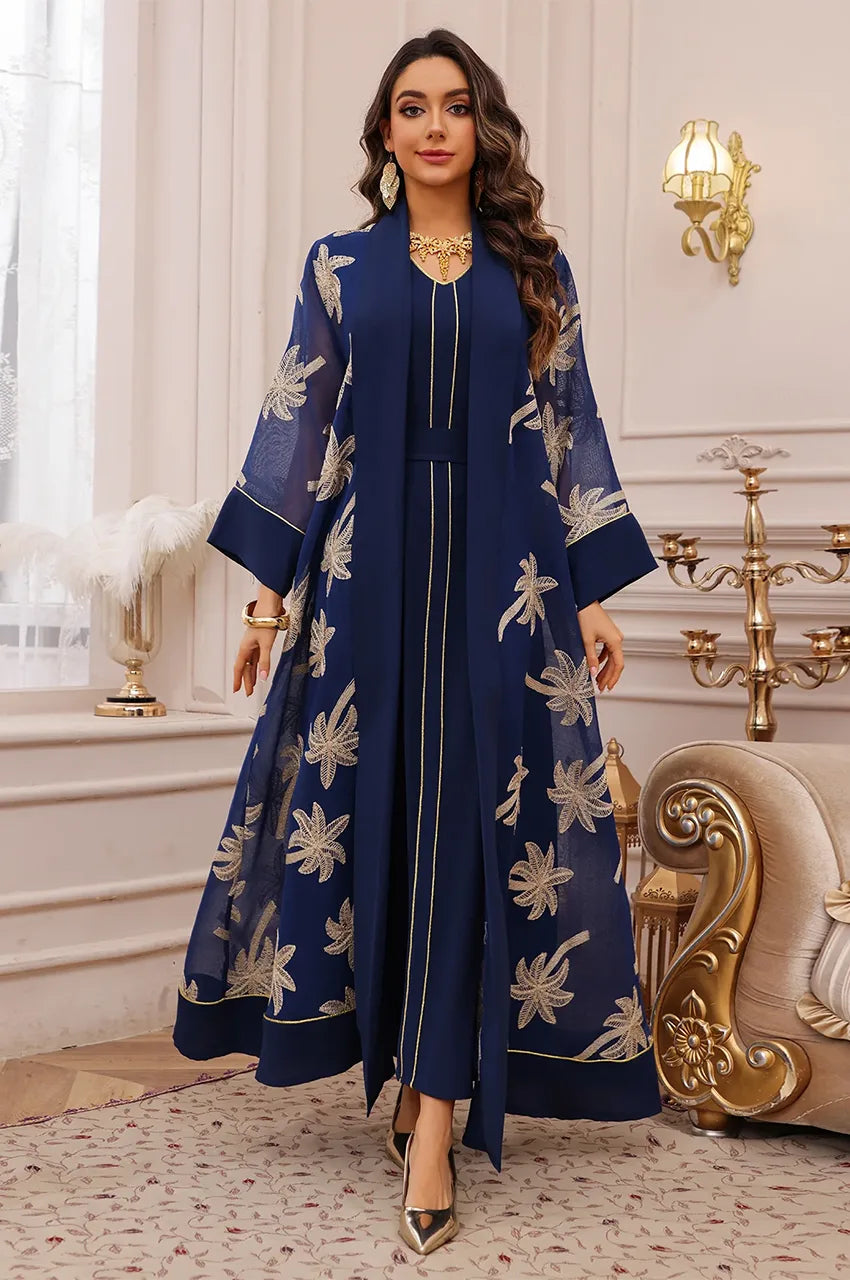 Dynamic shot of the dark blue palm tree kaftan showcasing the fluid open-front movement.