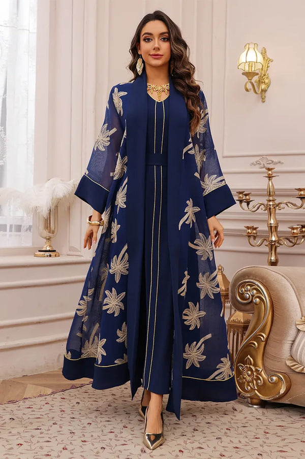 Dynamic shot of the dark blue palm tree kaftan showcasing the fluid open-front movement.