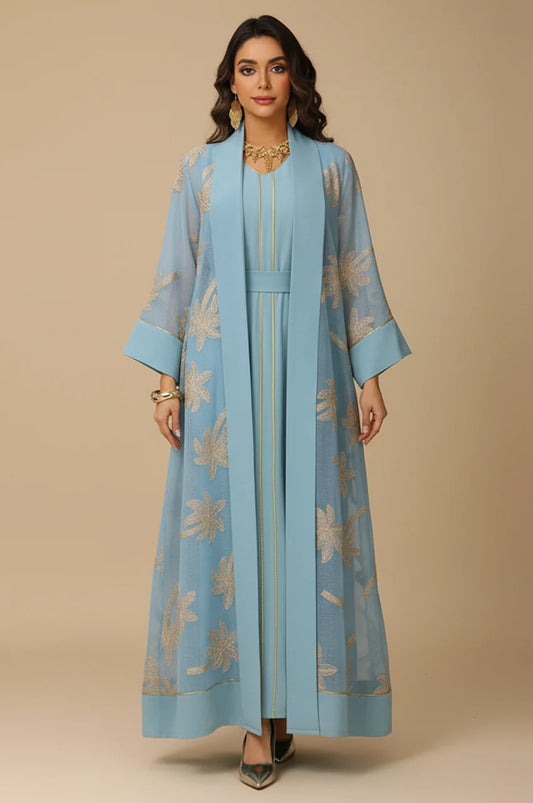 Front view of the SAELA light blue palm tree kaftan featuring gold botanical embroidery and a sheer organza overlay.