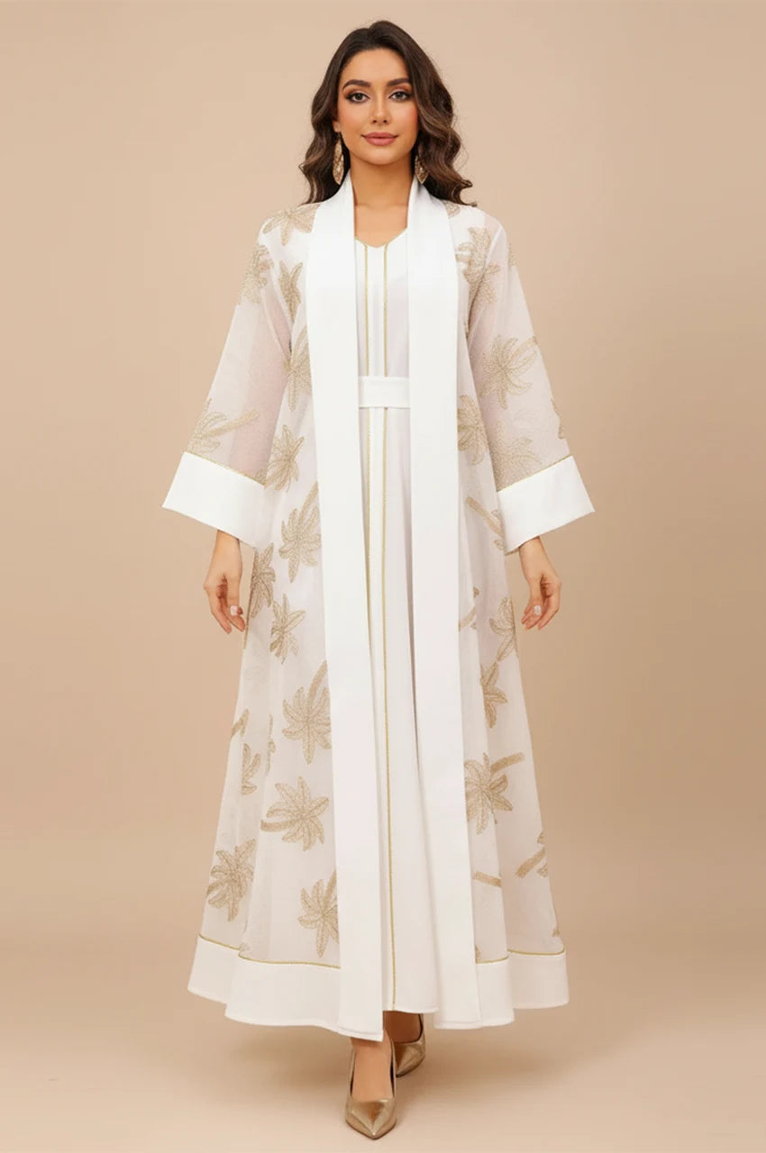 Front view of the SAELA white palm tree kaftan featuring gold botanical embroidery and a sheer organza overlay.