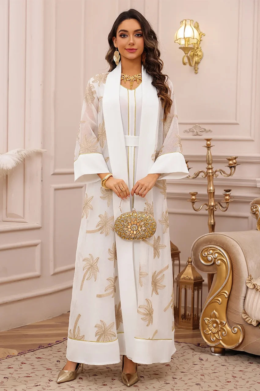 Detailed view of the structured sleeves and gold piping on the SAELA white palm tree kaftan.