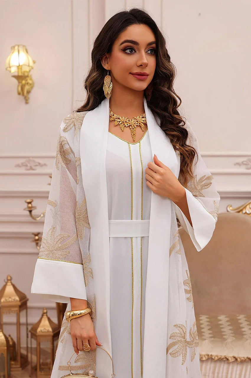 Close-up of the translucent organza and gold palm embroidery on the white palm tree kaftan.