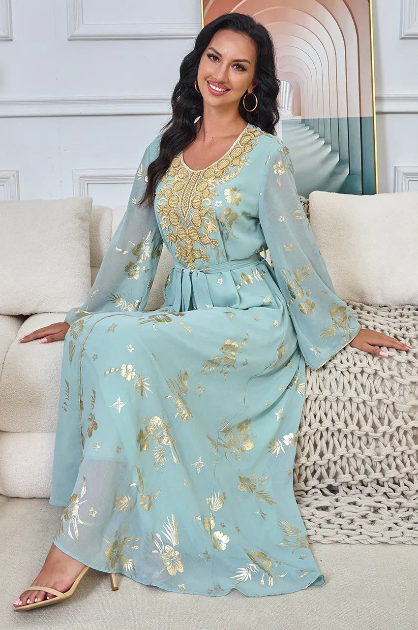 Seated lifestyle shot of the luxurious Malika Aqua moroccan kaftan evening dress for upscale events.