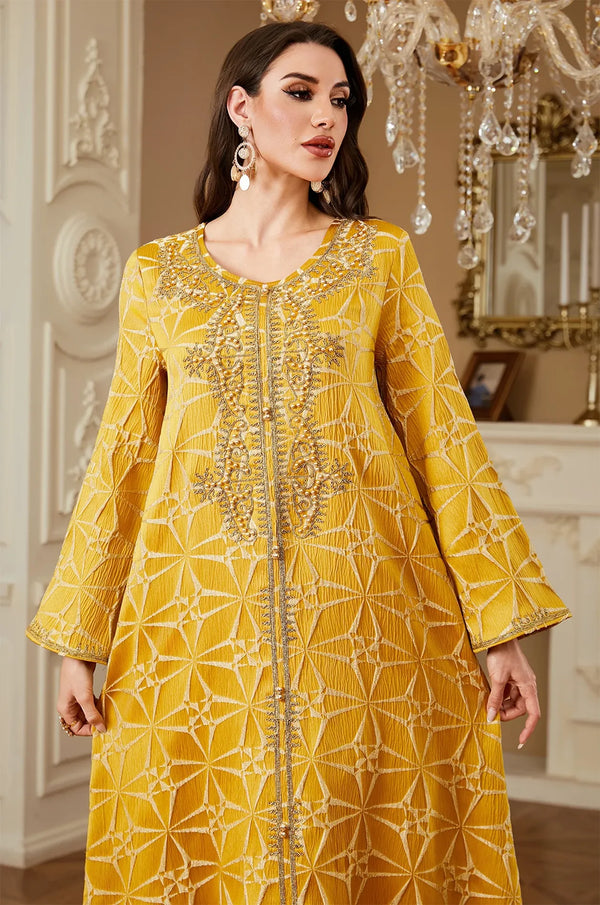 Close-up detail of the intricate gold embroidery and beaded neckline on the Selas Yellow textured kaftan.