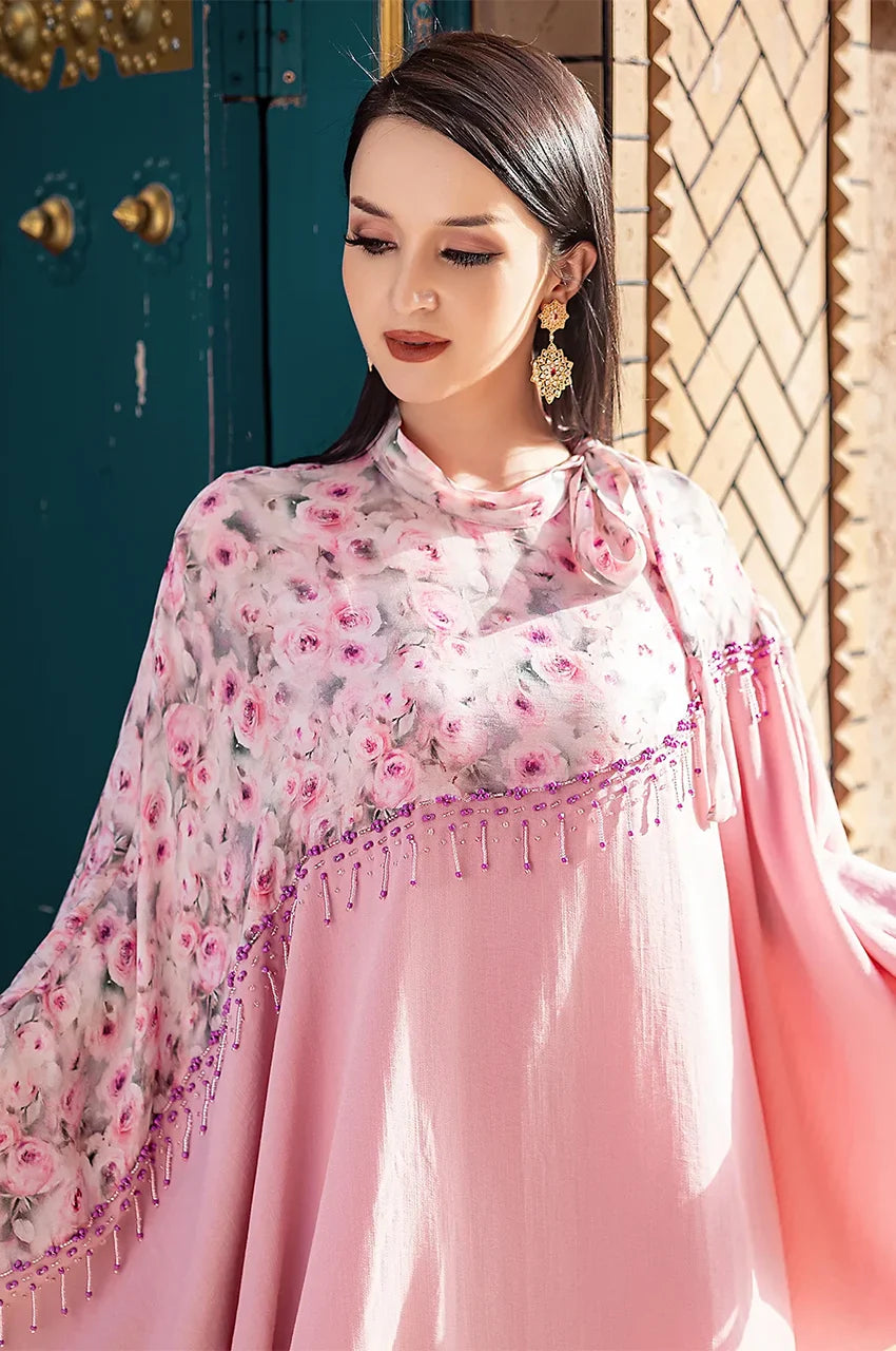 Closeup of model wearing Selena pink beaded kaftan with floral overlay and bead trim
