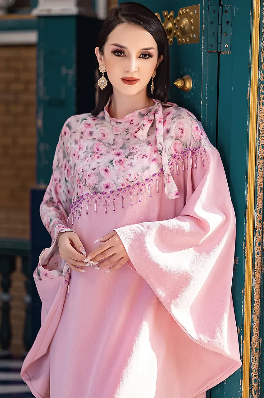 Portrait of model in Selena pink beaded kaftan showcasing floral print and beadwork