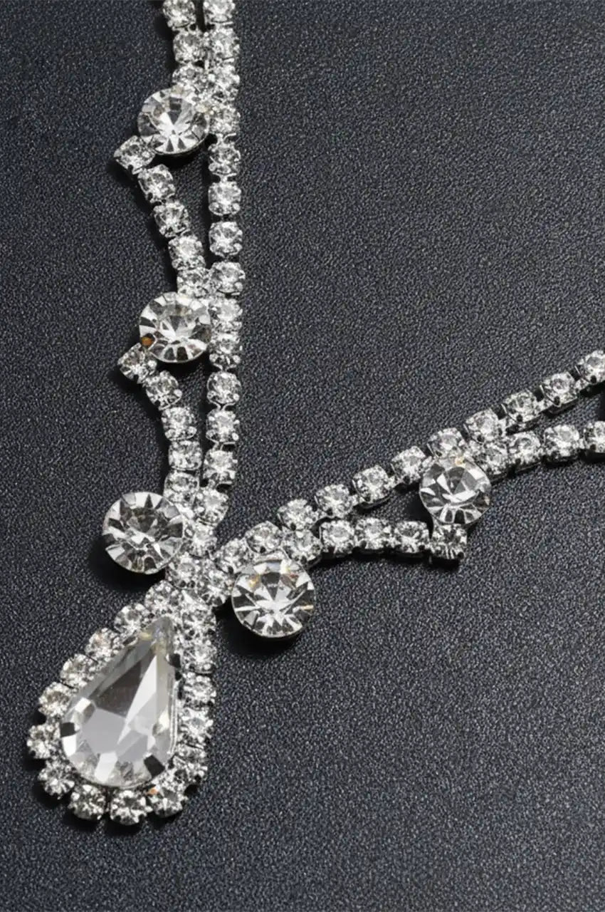 Close-up detail of the silver headpiece showing the teardrop crystal and rhinestone chain.