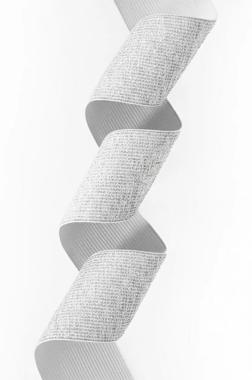 Detailed texture shot of the woven silver metallic elastic fabric used for the kaftan cinch belt.
