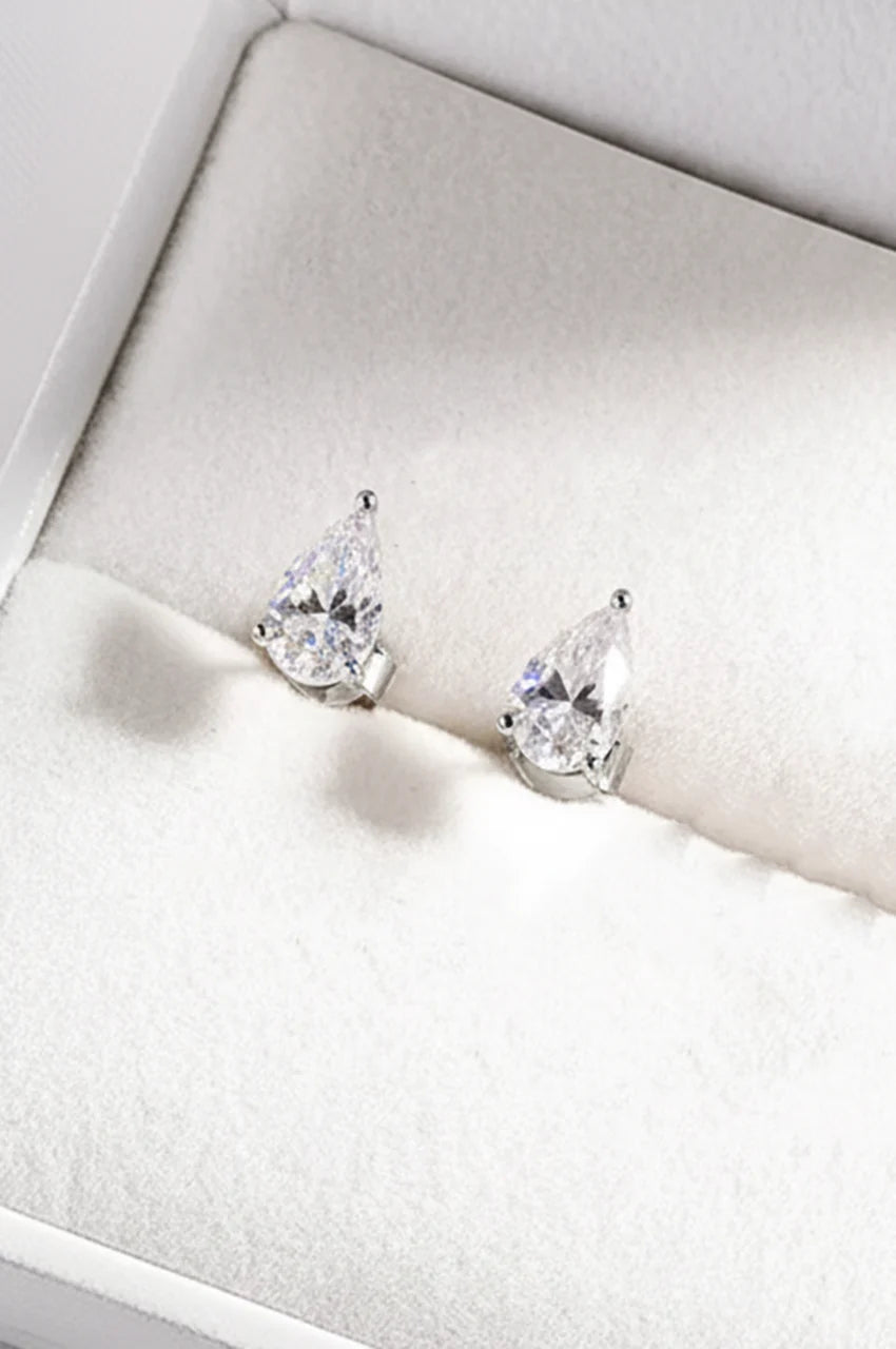 Pair of silver pear-cut cubic zirconia stud earrings displayed in a white jewelry box.