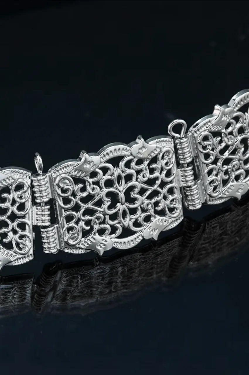 Close-up of the silver floral filigree plates and hinge connectors on the kaftan belt.