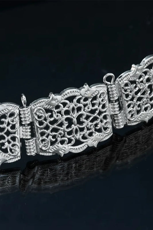 Close-up of the silver floral filigree plates and hinge connectors on the kaftan belt.