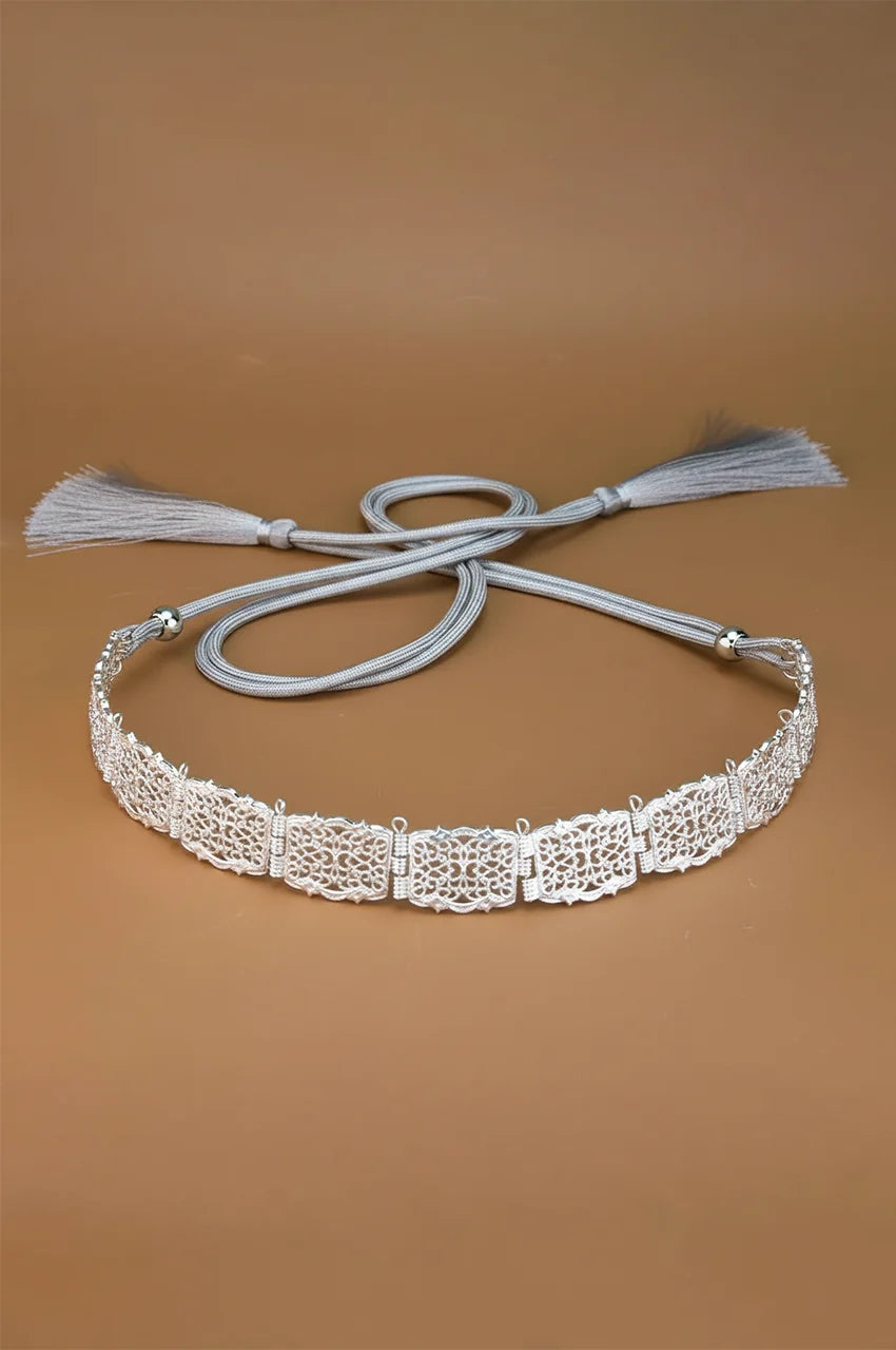 Full view of the Silver Square Filigree Belt with grey adjustable rope ties on a beige background.