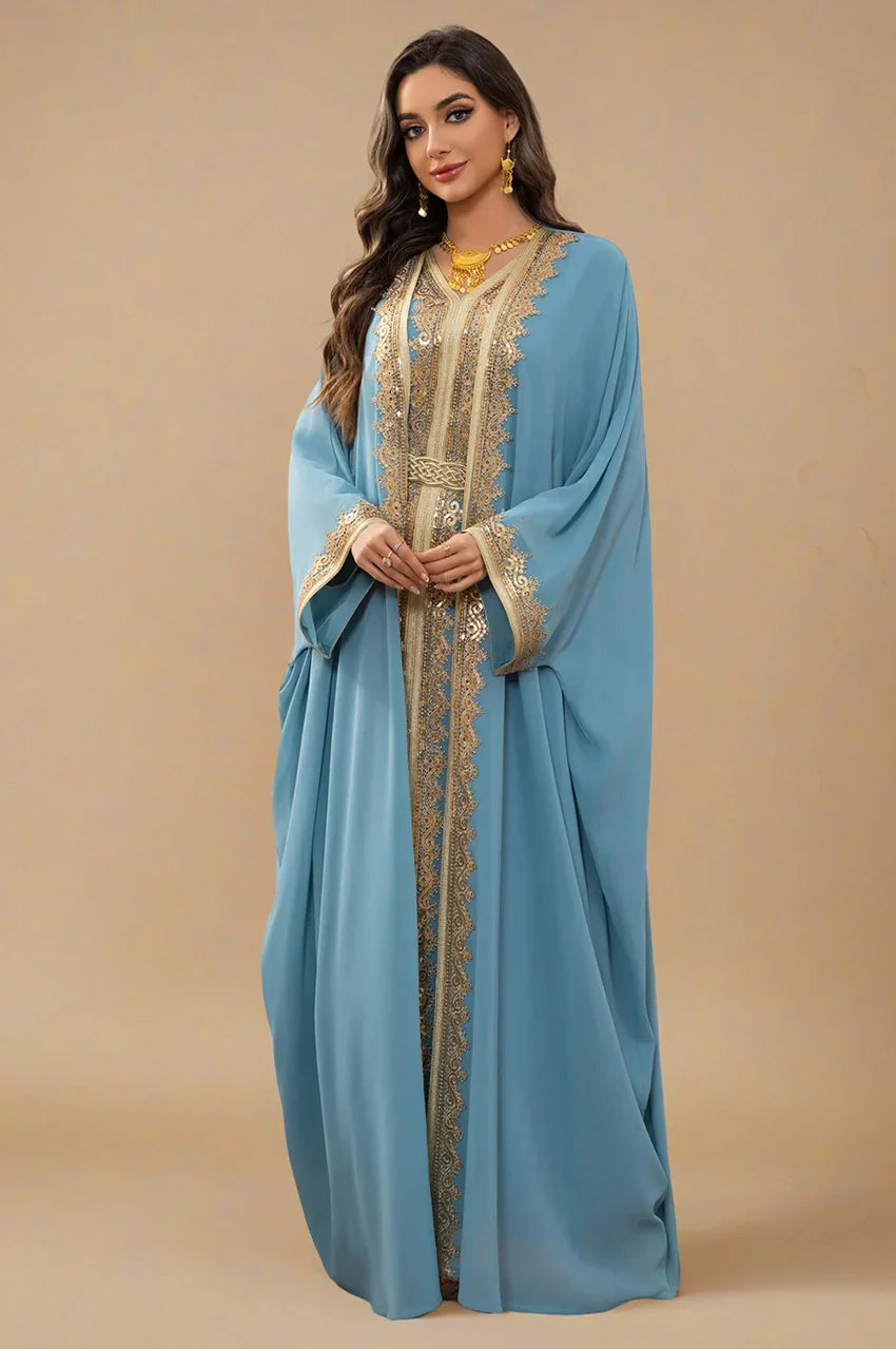 Portrait shot of the NAYRA long sheer kaftan in sky blue featuring gold jewelry and braided belt.