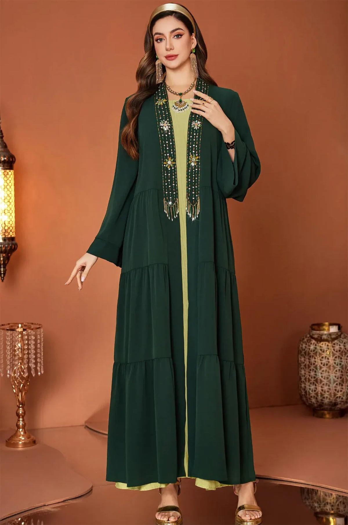 High-fashion pose of the forest green Thais beaded kaftan dress.