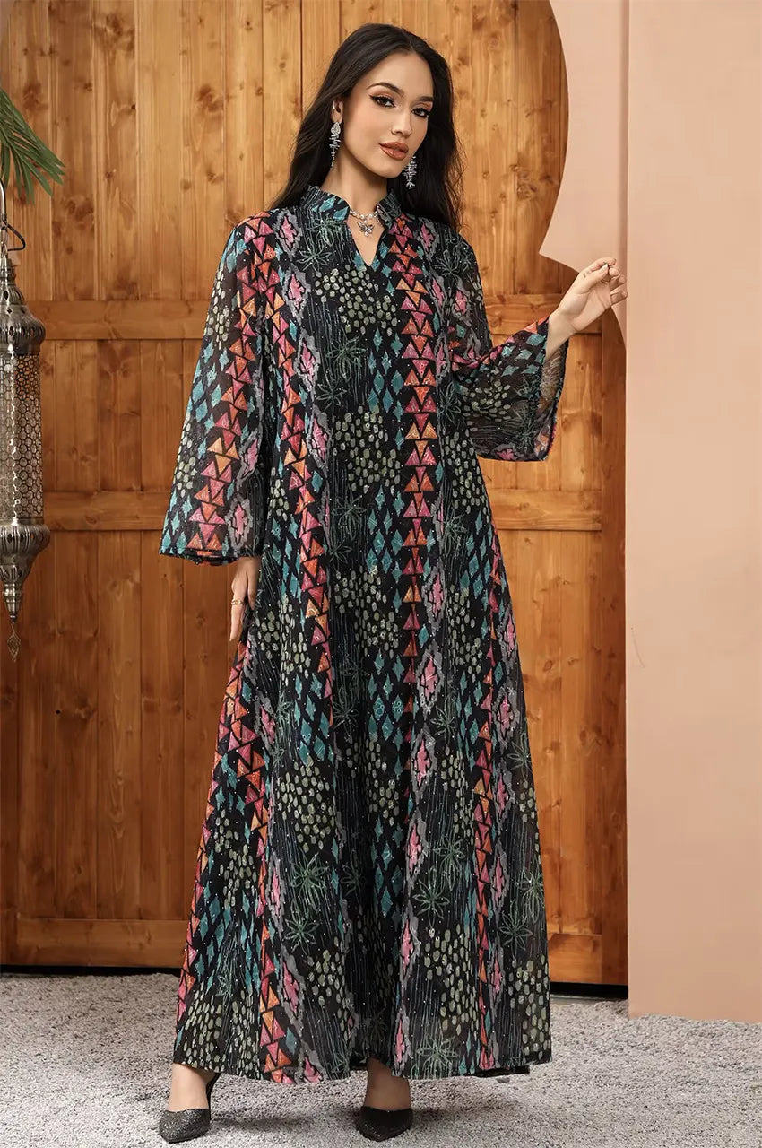 Posed full-length shot of the Tyrah black geometric print kaftan in a traditional arched doorway setting.