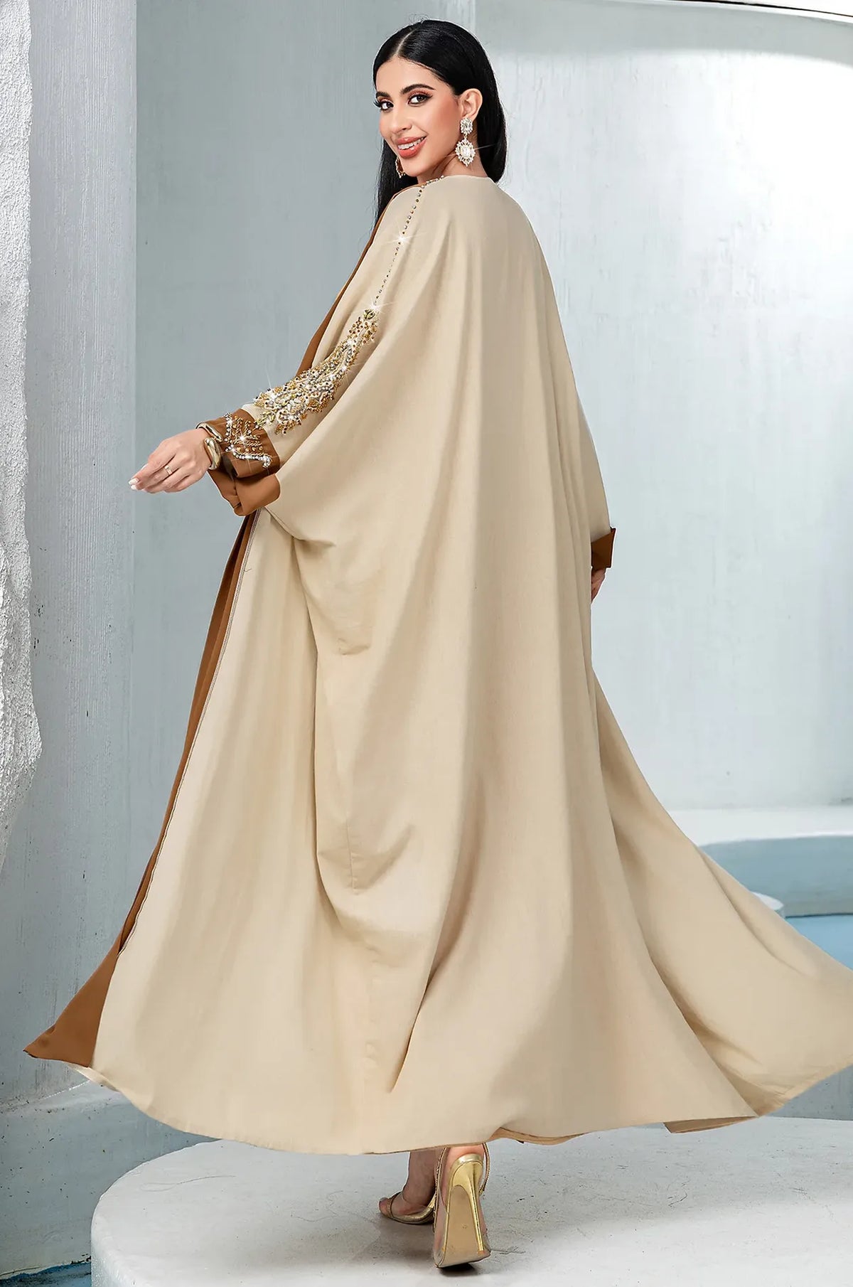 Movement shot showing the wide butterfly sleeves of the Vetta kaftan.