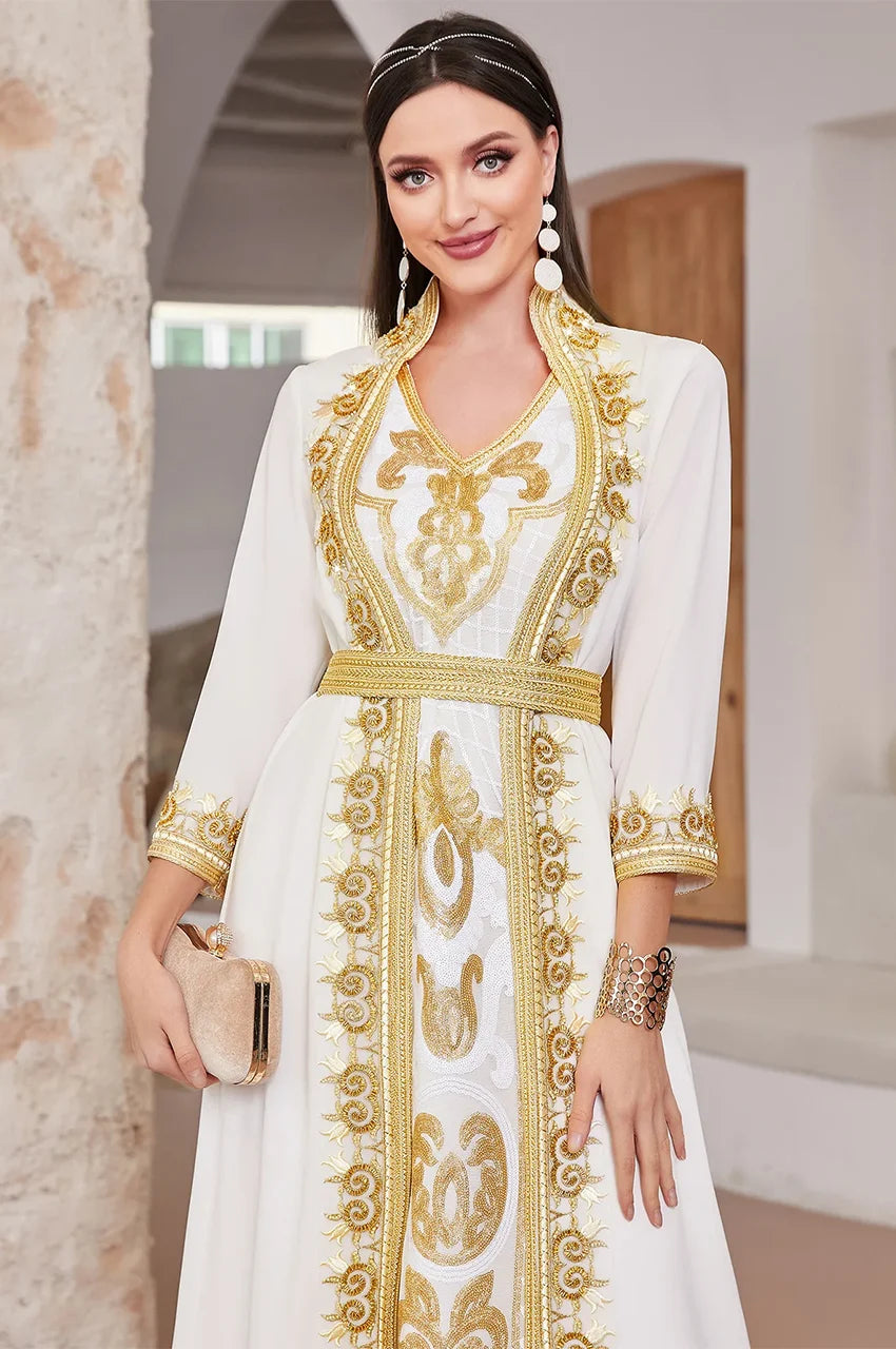 Close-up of the gold Sfifa braided trim and floral embroidery on the white chiffon kaftan.