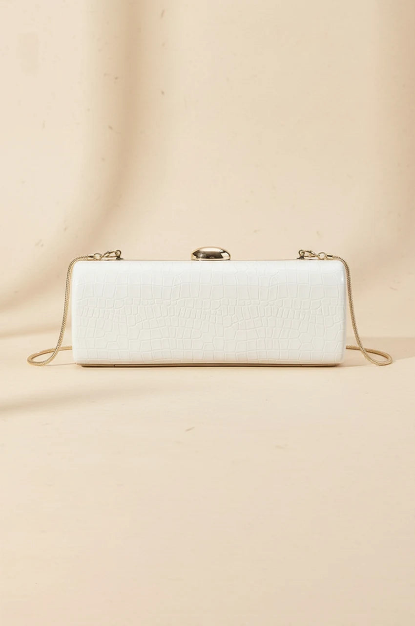 Front view of white patent leather cylinder evening bag with gold clasp and chain attachment points.