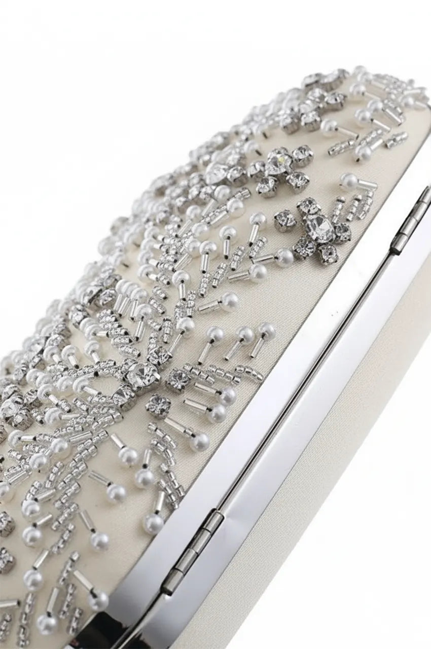 Angled top view of white oval minaudière showcasing the density and shine of the crystal and pearl floral vine pattern.