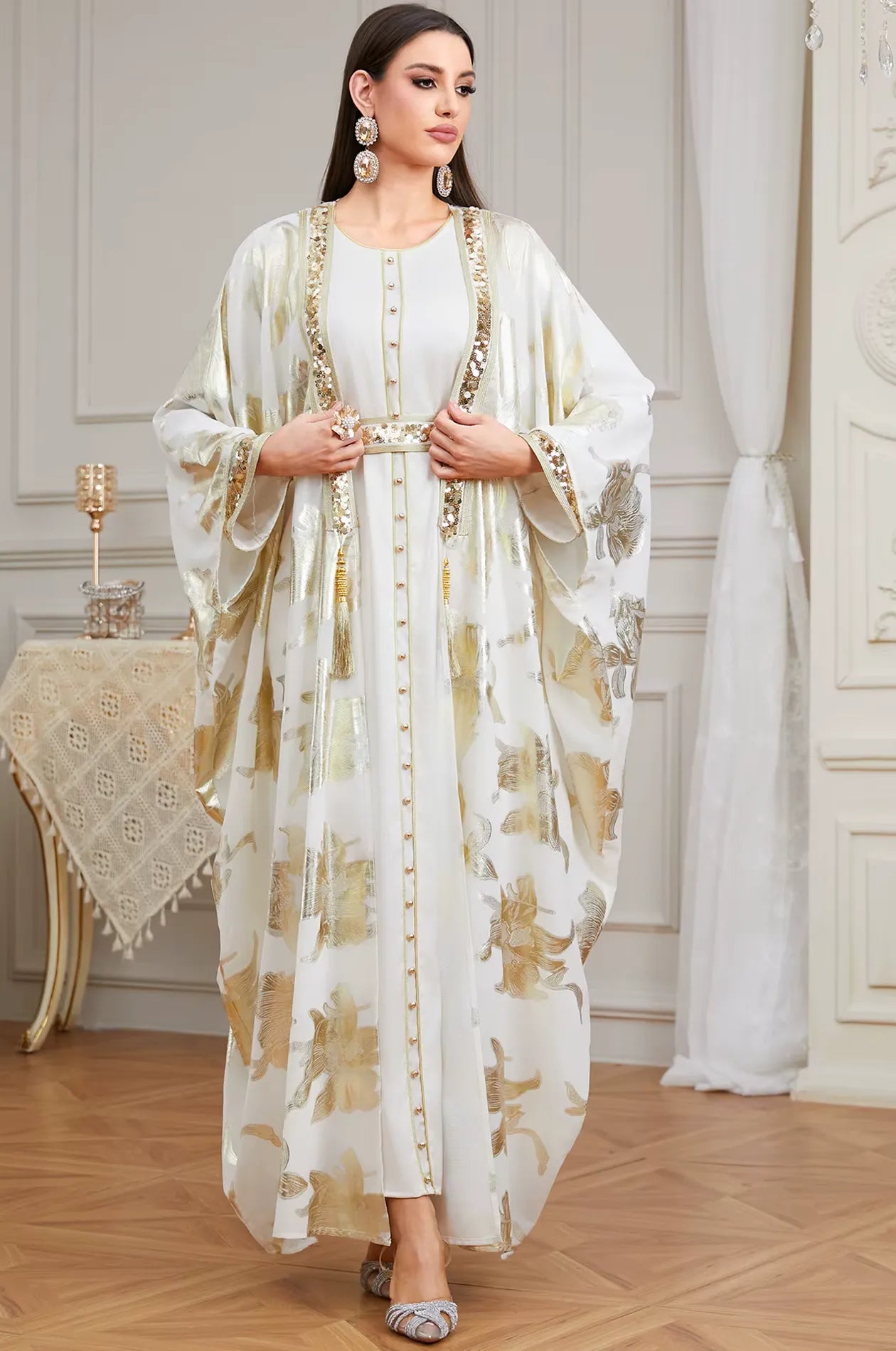Close-up of the white Puppis kaftan luxe showcasing the adjustable gold sequined belt and elegant tassel details on the lapel.