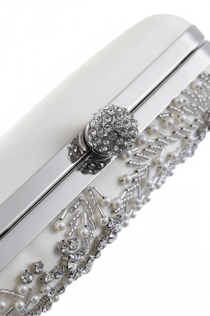 Detail shot of the top edge of the white wedding bag, focusing on the silver hardware construction and bead placement.
