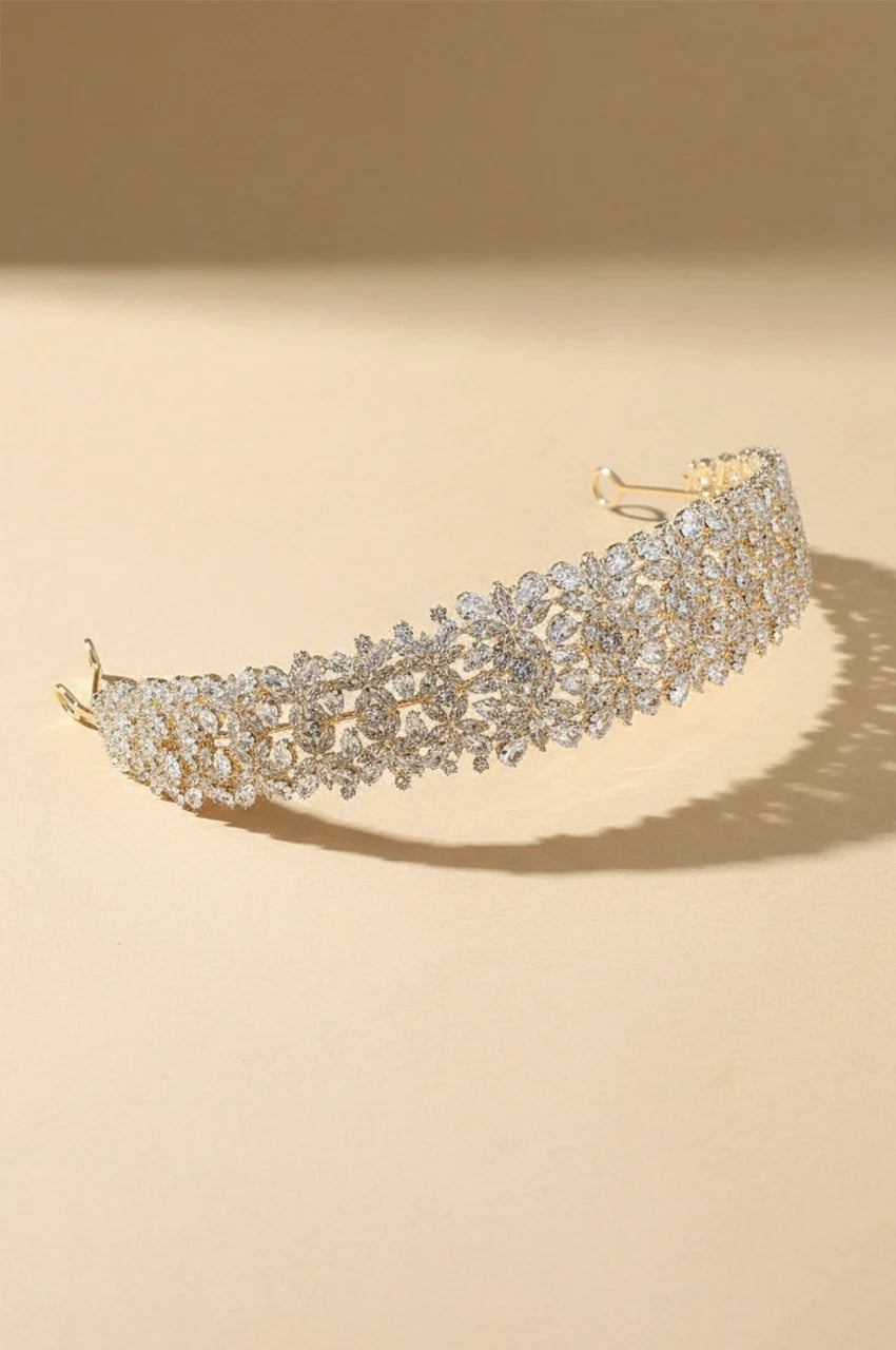 Isolated view of the Wide Gold-Tone Floral Headband on a cream background.
