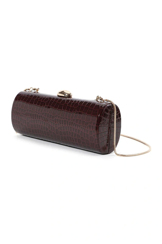 Angled view of the deep red wine crocodile embossed cylinder bag showing its glossy finish and shape.