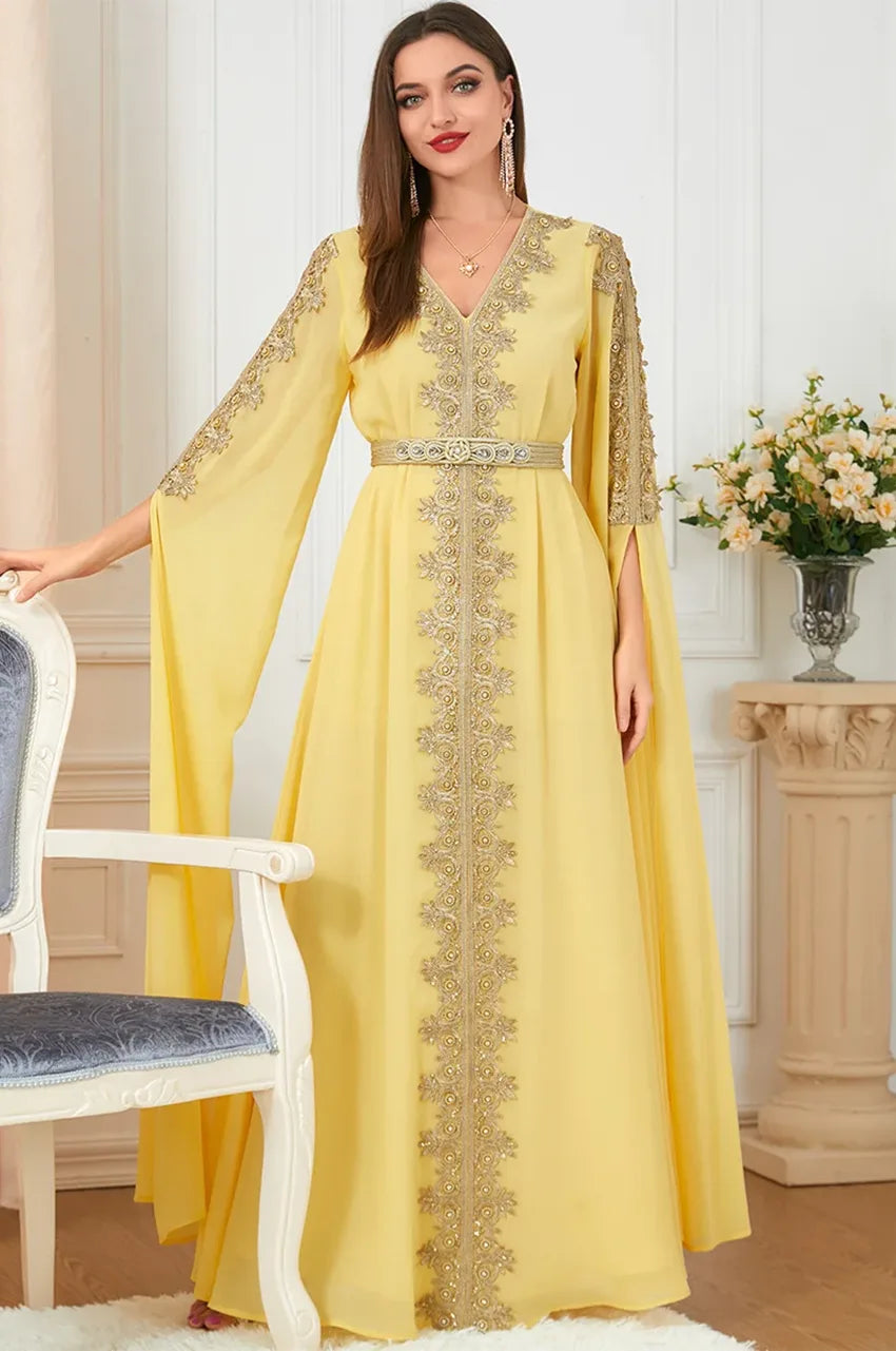 Standing model in yellow embroidered kaftan dress with gold belt detail