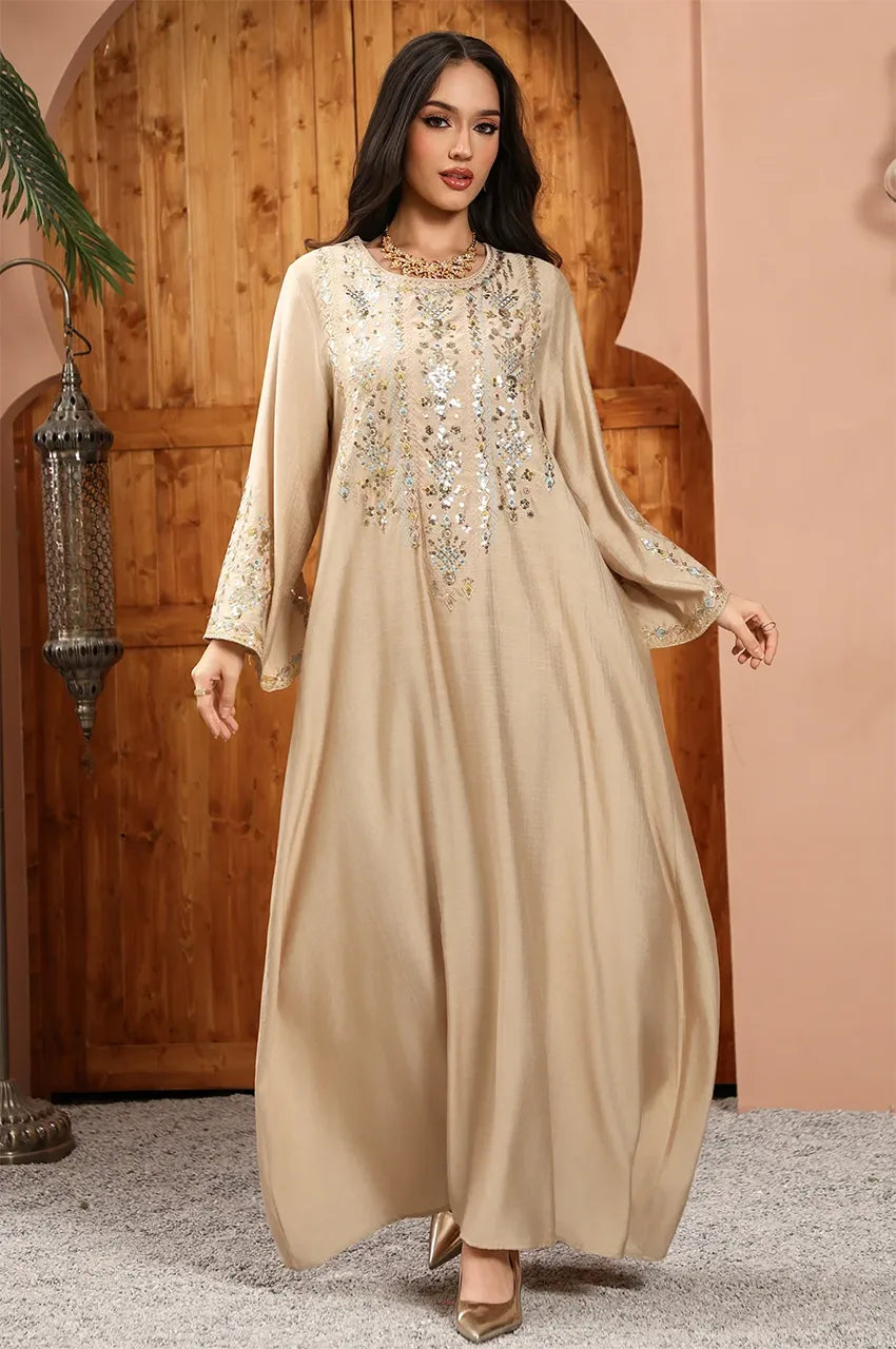 Dynamic shot of the Zahia beige Saudi kaftan showcasing fabric flow and elegance.