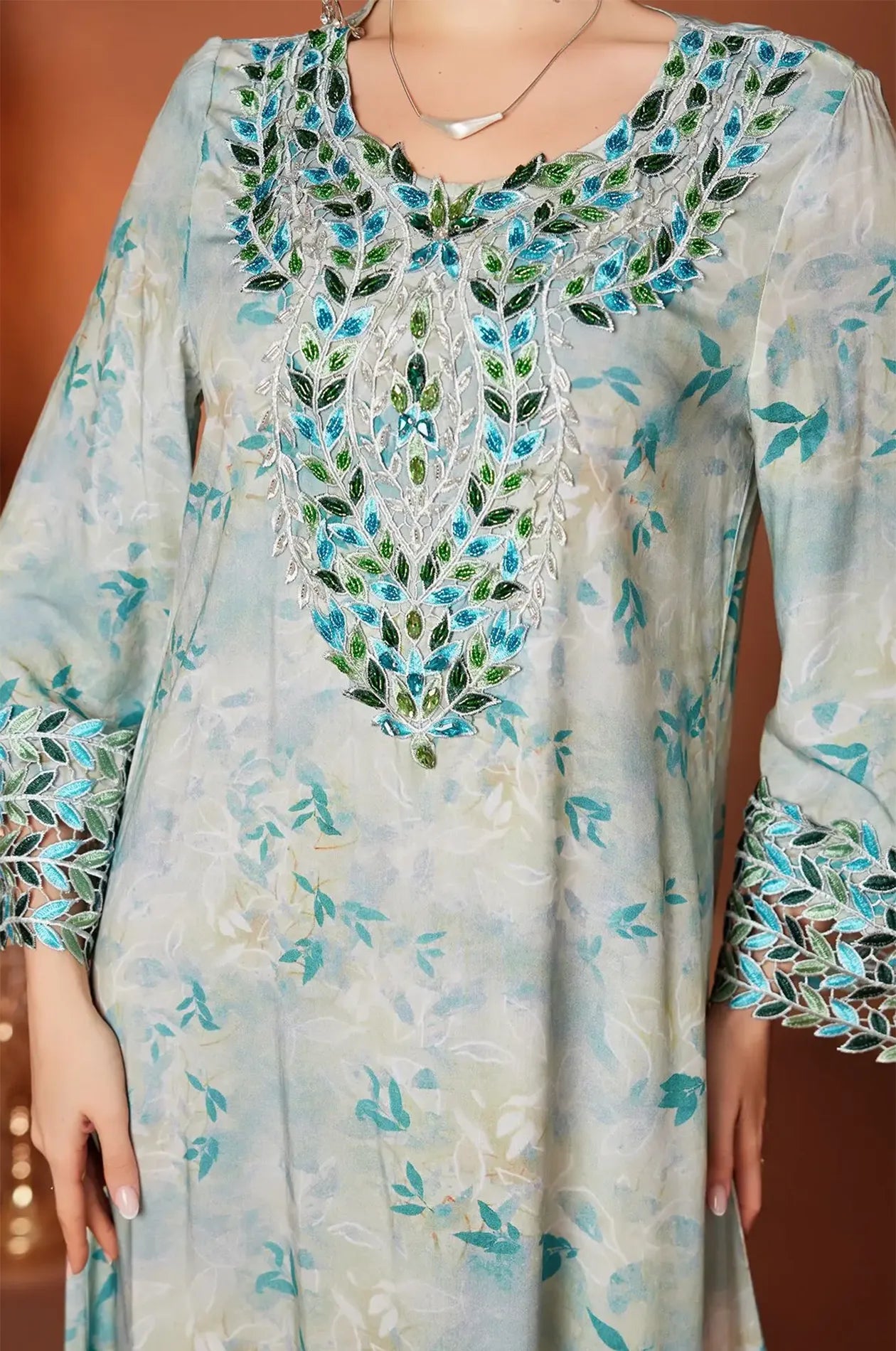Close-up of the teal and emerald hand-beaded embroidery on the Zahri Kaftan.
