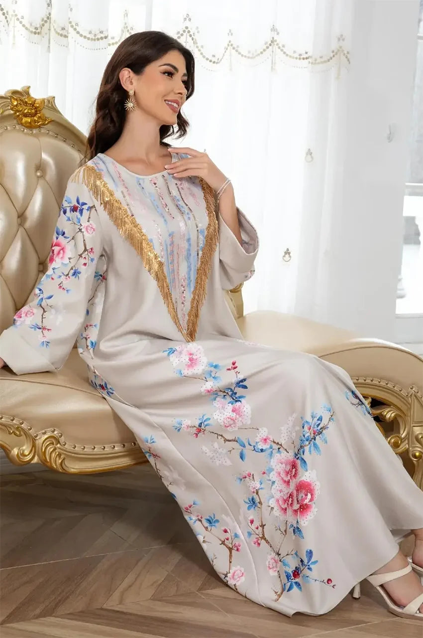 Woman sitting in a Zaree gold sequin kaftan showing floral details.