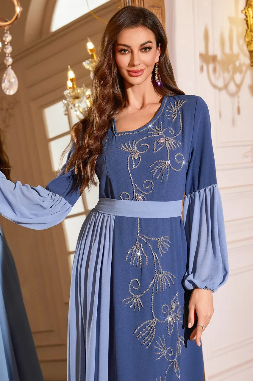 Close up of Zaria pleated kaftan dress showing blue floral crystal embroidery.