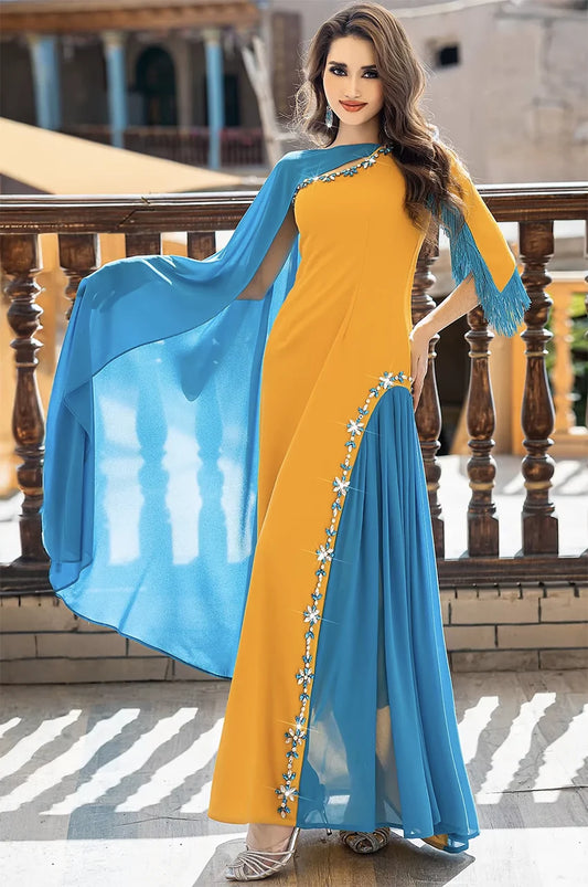 Fashion photography of the Zayna kaftan cape featuring the dramatic teal cape draped over a balcony.