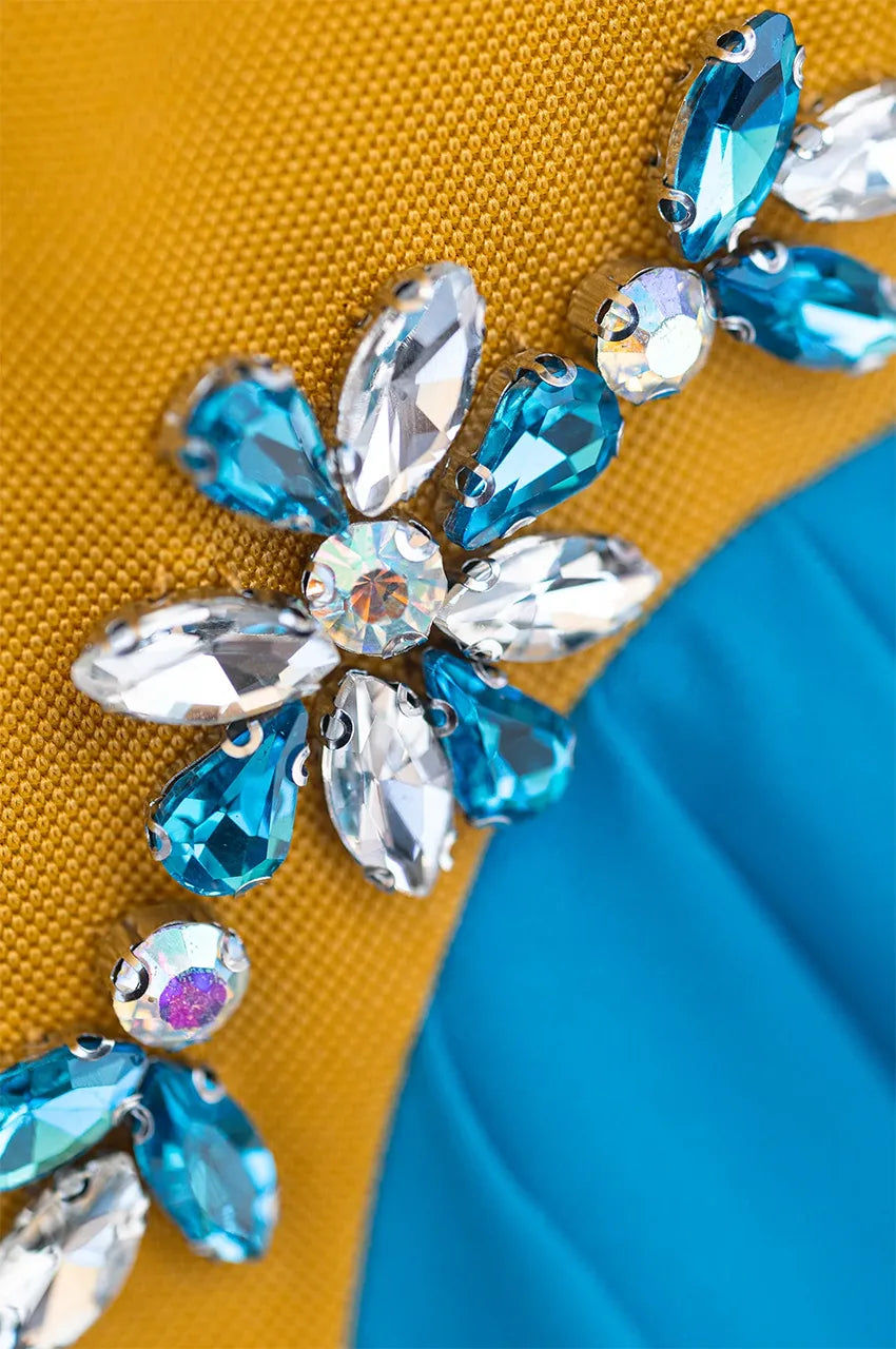 Extreme close-up of the hand-applied crystal floral motifs on the Zayna kaftan cape.