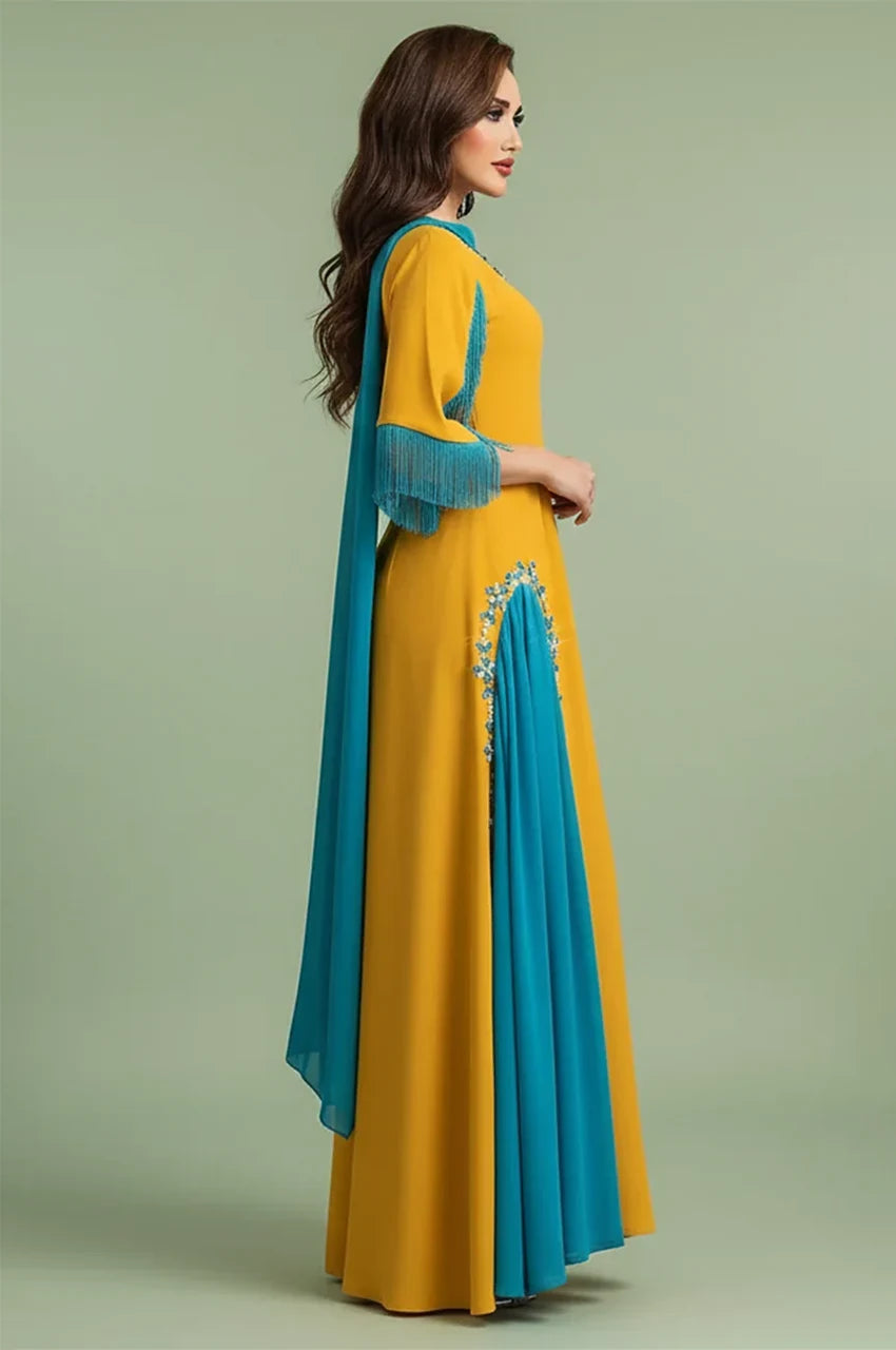 Side profile of Zayna kaftan cape highlighting the teal side pleat and fringed sleeve detail.