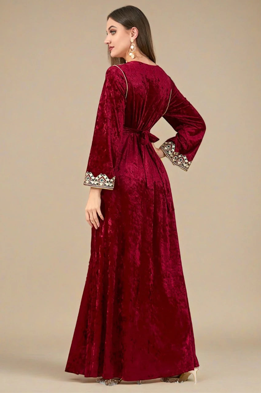 Back angle view of Zaynah red Moroccan velvet kaftan featuring waist tie and embroidered details