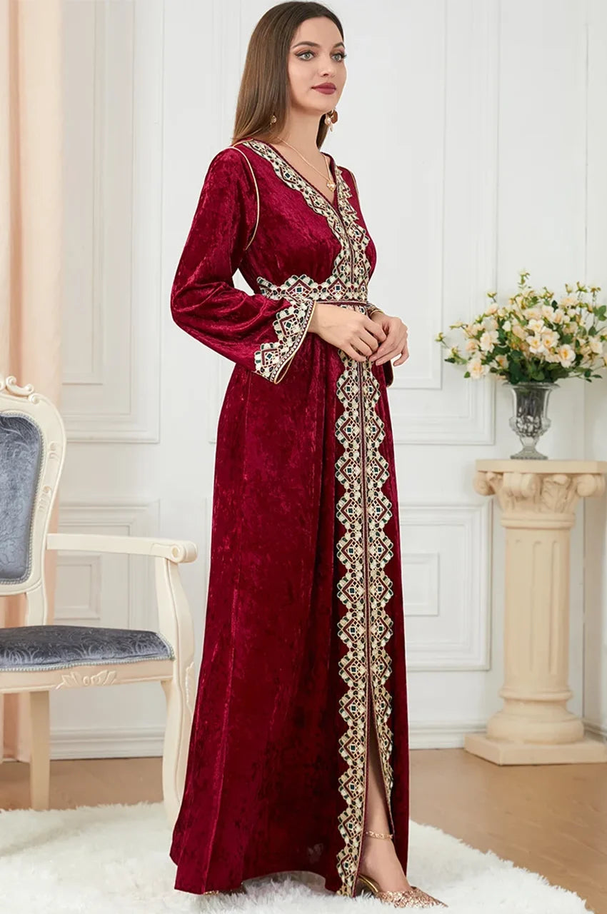Side angle of Zaynah red Moroccan velvet kaftan showing embroidered sleeves and belt